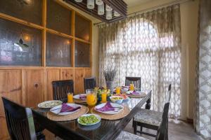 una sala da pranzo con tavolo e cibo di Stay Vista at Ivy Manor a Srinagar
