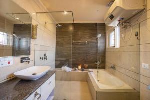 bagno con vasca, lavandino e doccia di Stay Vista at Ivy Manor a Srinagar
