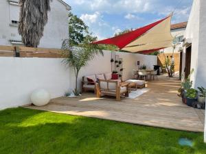 einen Hinterhof mit einer Holzterrasse mit einem Tisch und Stühlen in der Unterkunft Mini Villa Indépendante à 350m de la mer (LAX) in Lucciana