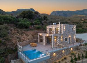 an aerial view of a stone house with a swimming pool at Nature Villas Myrthios in Plakias