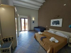 a bedroom with a large bed and a blue couch at Le Plejadi in Castellammare del Golfo