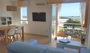 a living room with a blue couch and a table with a view at La Savina Ses Platgetes in La Savina