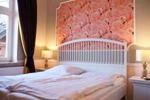 a bedroom with a white bed with a wall with flamingos at Hotel Hof Kirchhorst in Groß Wittensee