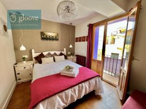 1 dormitorio con 1 cama grande con manta roja en Hostal - Restaurante Nomadas by Gloove, en Villalba de la Sierra