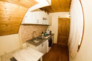 una pequeña cocina con fregadero y techo de madera. en Vintage Art Rooms, en Tiflis