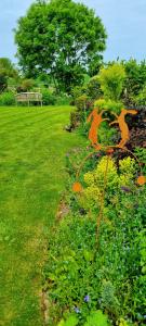 a garden with flowers and a bench in a park at The Nest in Coveney