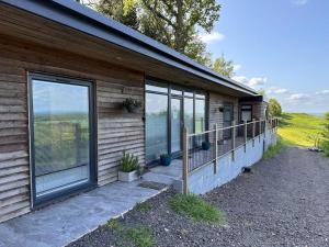 a wooden house with a large sliding glass door at Ridge House Stables in Ashford
