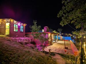 una casa iluminada por la noche con luces en Traveller Hive Kasar Devi en Almora
