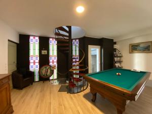 a living room with a pool table and stained glass windows at Chambre & salle de bain privée - LV 33 in Argenton-sur-Creuse