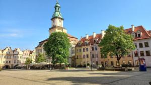 een gebouw met een klokkentoren op een stadsplein bij Plac Ratuszowy 50 - Old Town in Jelenia Góra