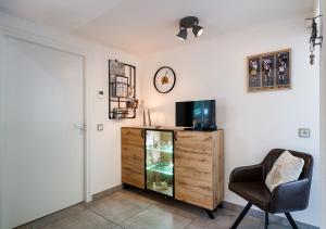 Zimmer mit einem TV, einem Stuhl und einem Schrank in der Unterkunft Velo-Droom in Otterlo