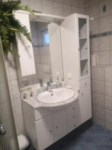 La salle de bains blanche est pourvue d'un lavabo et d'un miroir. dans l'établissement Landhaus Knoflach, à Neustift im Stubaital