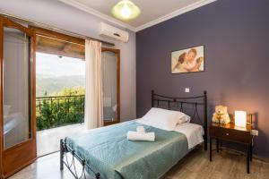 een slaapkamer met een bed en een groot raam bij Virginia - Home in Helmata Argostoli in Argostoli