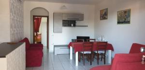 ein Wohnzimmer mit einem roten Tisch und Stühlen in der Unterkunft Casa di Ale in Siniscola