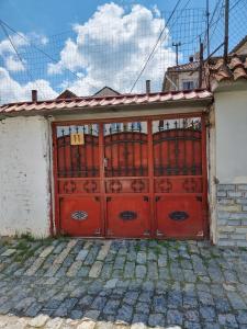 a garage with a red door on a house at Liora's Place in Korçë