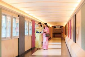 Due donne in kimono in piedi in un corridoio di Ooedo Onsen Monogatari Hotel New Shiobara a Nasushiobara