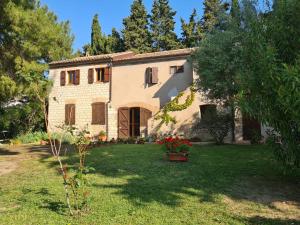 a large stone house with a yard with flowers at Il Casale Delle Farfalle in Sirolo