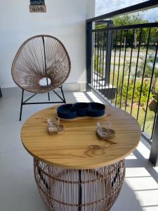 Lar aconchegante Praia do Forte في برايا دو فورتي: طاولة خشبية مستديرة مع أطباق زرقاء وكرسي