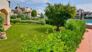 un giardino con un albero in mezzo a un cortile di Resort il cigno a Peschiera del Garda