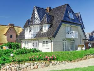 une grande maison blanche avec un toit en gambrel dans l'établissement Abaluga 3A, à Wenningstedt