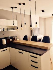 uma cozinha com um balcão com cadeiras e luzes em 2 BED APARTMENT IN BANSKO RESORT em Bansko