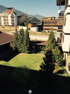 2 BED APARTMENT IN BANSKO RESORT في بانسكو: اطلالة على ساحة فيها اشجار ومباني
