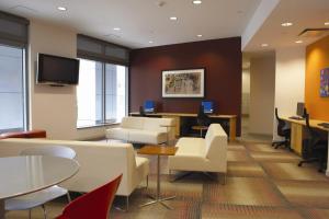 a waiting room with white chairs and tables and a tv at Cambridge 1BR w Gym WD nr Kendall Sq BOS-585 in Cambridge