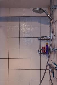 y baño con ducha y azulejos blancos. en City Center Boutique Apartment, en Gante