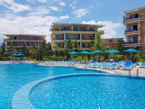 a swimming pool with chairs and umbrellas in a resort at Luxury Dreamland Oasis Apartments in Chakvi