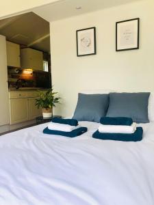 een wit bed met blauwe kussens erop bij Tiny house 't Heidehoes in Usselo in Enschede