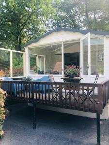 a gazebo with a screened in porch with flowers at Tiny house 't Heidehoes in Usselo in Enschede