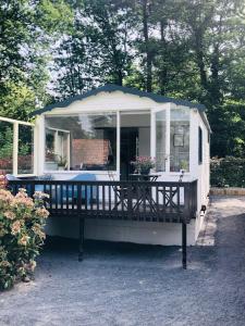 a small house with a porch and a table at Tiny house 't Heidehoes in Usselo in Enschede