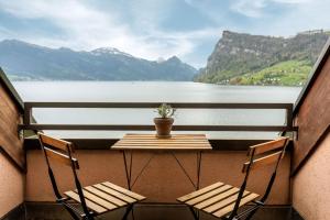 einen Tisch und Stühle auf einem Balkon mit Seeblick in der Unterkunft Seehotel Kastanienbaum in Luzern
