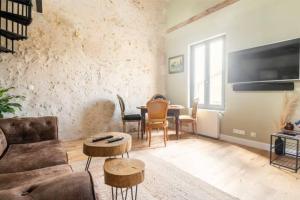 sala de estar con sofá y mesa en Le Loft Bergeracois, en Bergerac