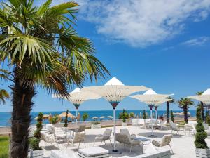 a beach with chairs and umbrellas and the ocean at Luxury Dreamland Oasis Apartments in Chakvi