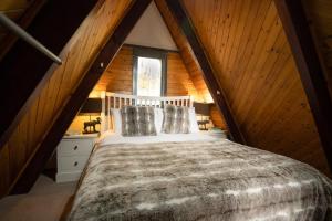 a bedroom with a large bed in a attic at Wolf Lodge in Carrbridge