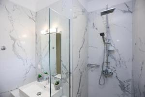 a bathroom with a shower and a sink and a mirror at Kouros apartments in Litherés
