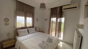 アフィトスにあるAmazing Sea View Loft, Afytosのタオルが敷かれた大きな白いベッドのある寝室