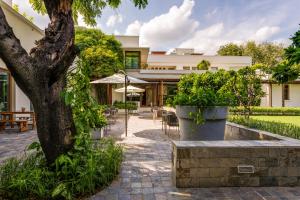 una casa con un patio con un árbol en The Manor - New Delhi, en Nueva Delhi