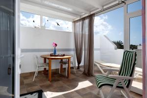 プラヤ・ブランカにあるCasa Mariaのテーブルと椅子、窓が備わる客室です。
