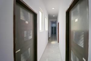 um corredor com duas portas castanhas e um corredor com um hallwayngth em OYO 71370 White House em Garhi Harsāru