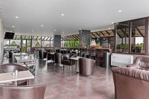 a restaurant with leather chairs and tables and a bar at Hotel Charter Otopeni in Otopeni