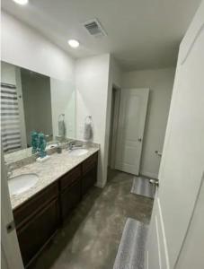 a bathroom with two sinks and a large mirror at Fully Furnished with Full Kitchen Appliances, 3 Bedroom and 2 Bath Home in Killeen