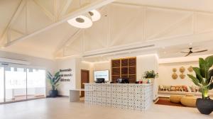 an office lobby with a reception desk and a couch at Ilunion Menorca in Cala Galdana +37 photos