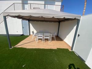 patio con tavolo e sedie sotto un baldacchino di vistalmar 1 casa verde a San Juan de Alicante