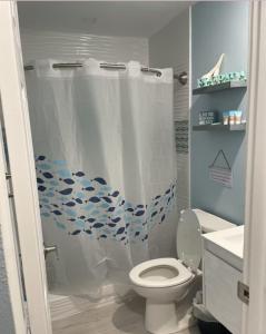 a bathroom with a shower curtain with a toilet at Manasota Key Cottage B in Englewood