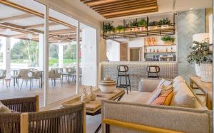 Ilunion Menorca في كالا غلدانا: غرفة معيشة مع أريكة وطاولة