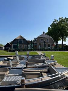 a row of chaise lounges in front of a house at LODGE, een super knus tiny house, nabij vaarwater en haven! in Belt-Schutsloot