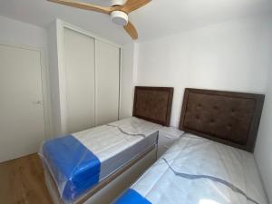 um quarto com 2 camas e uma ventoinha de tecto em vistalmar 1 casa verde em San Juan de Alicante