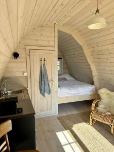 a bedroom with a bed in a wooden room at LODGE, een super knus tiny house, nabij vaarwater en haven! in Belt-Schutsloot